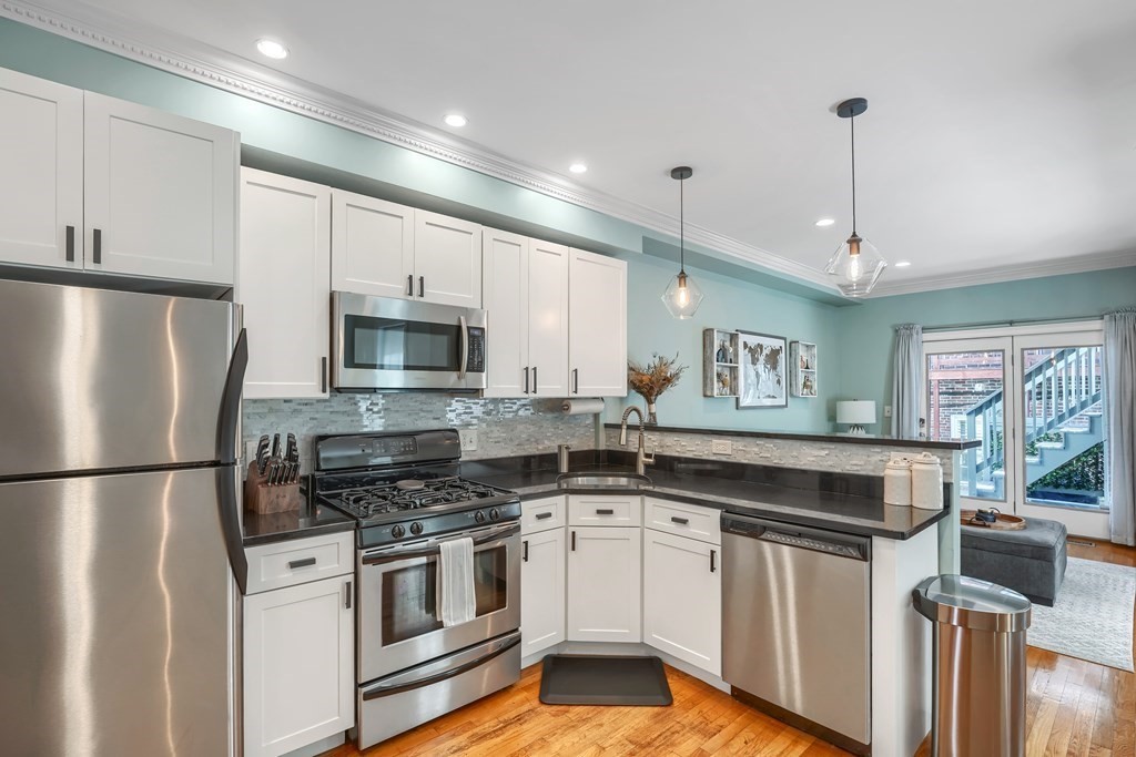 a kitchen with stainless steel appliances granite countertop a stove a sink and a refrigerator