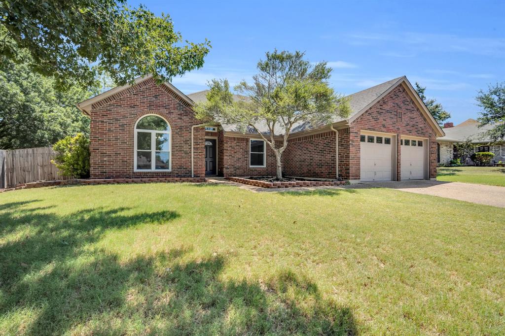 a front view of a house with yard and garage