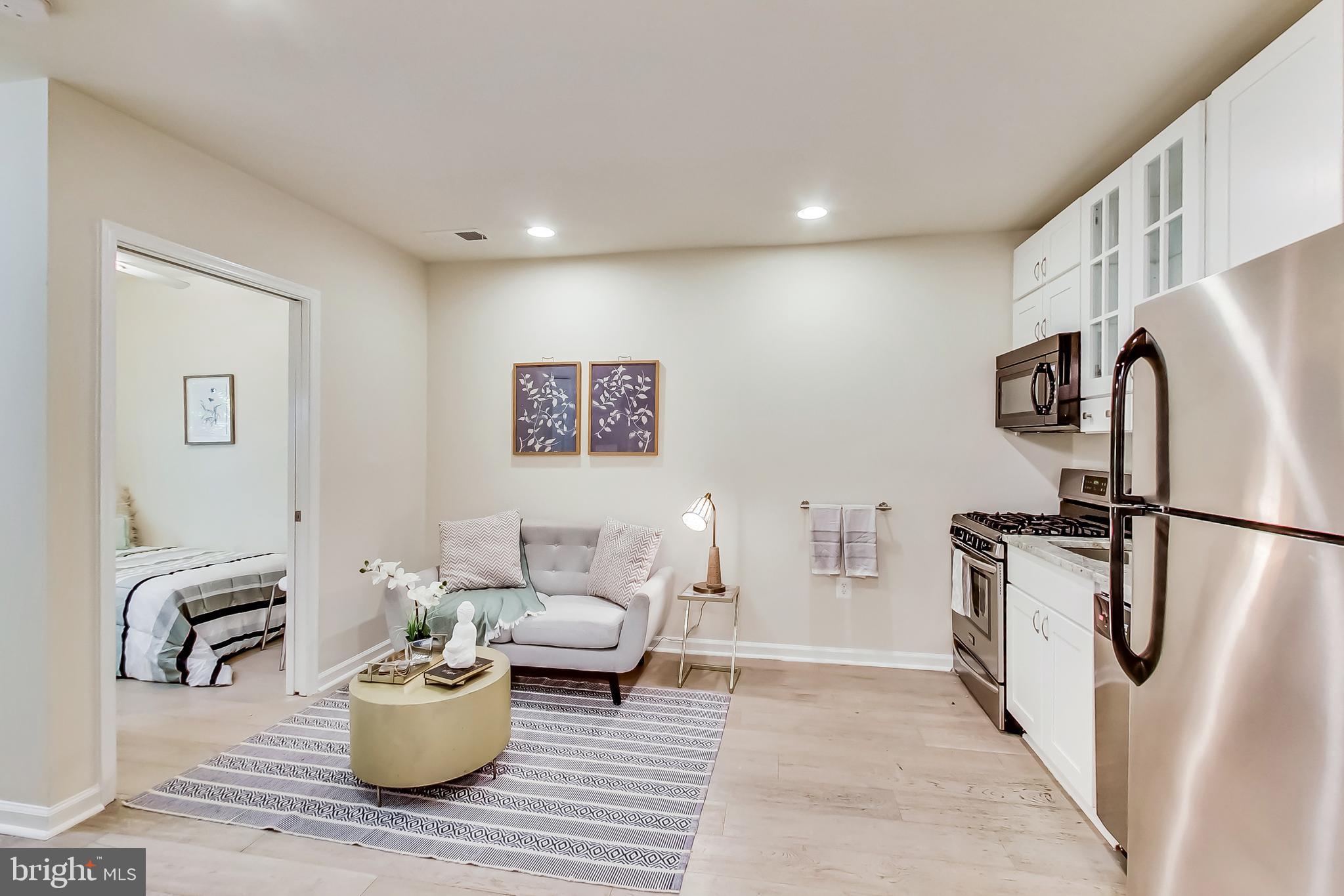 a living room with furniture and a refrigerator