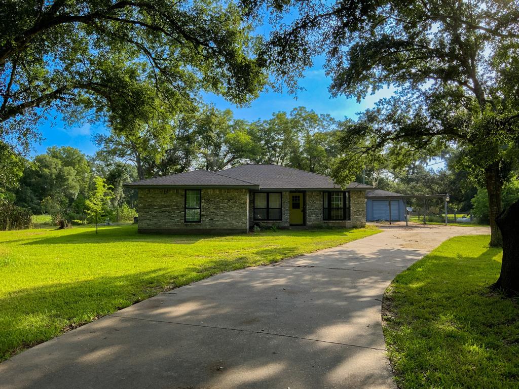 a front view of a house with a yard and trees