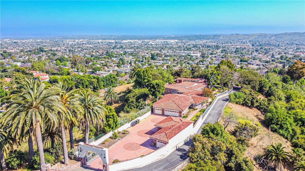 an aerial view of residential houses with outdoor space and trees