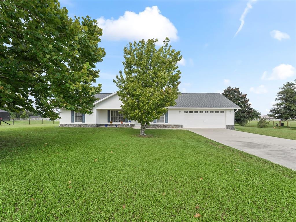 a view of a house with a yard and tree s