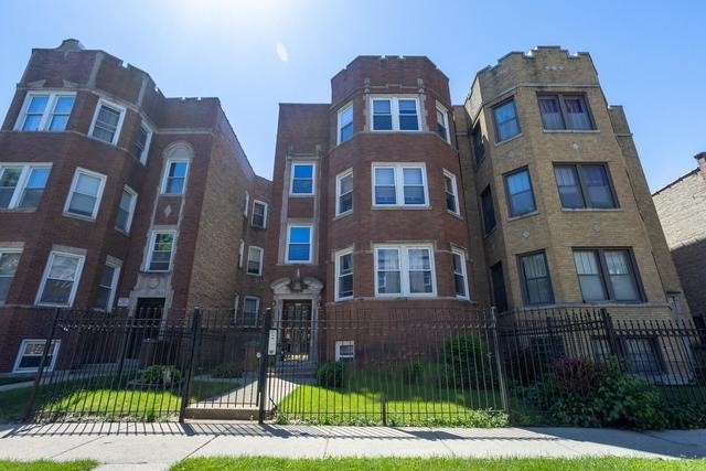 a front view of a residential apartment building with a yard