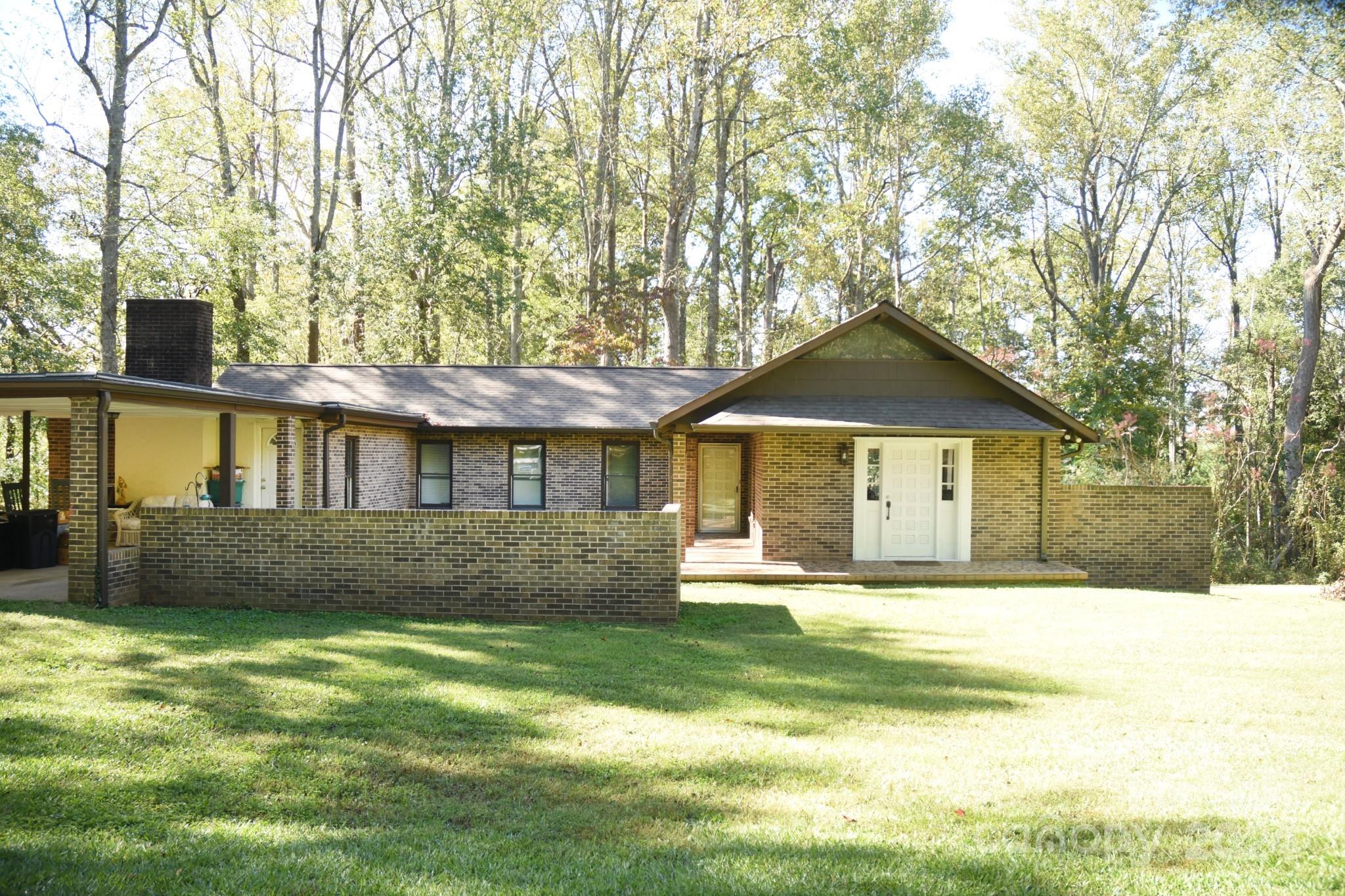 a front view of a house with a yard and trees