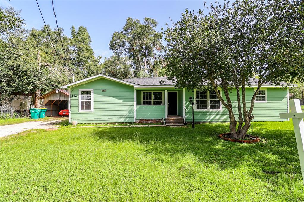 a view of a house with a yard and sitting area