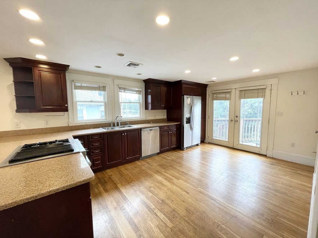 a large kitchen with stainless steel appliances granite countertop a stove a sink and a refrigerator