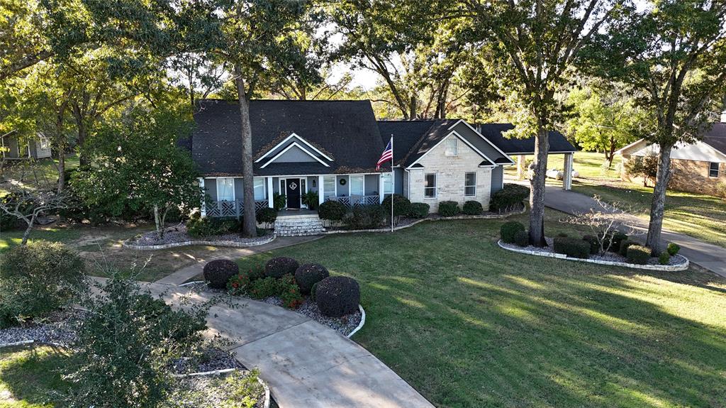 a front view of a house with a yard and trees