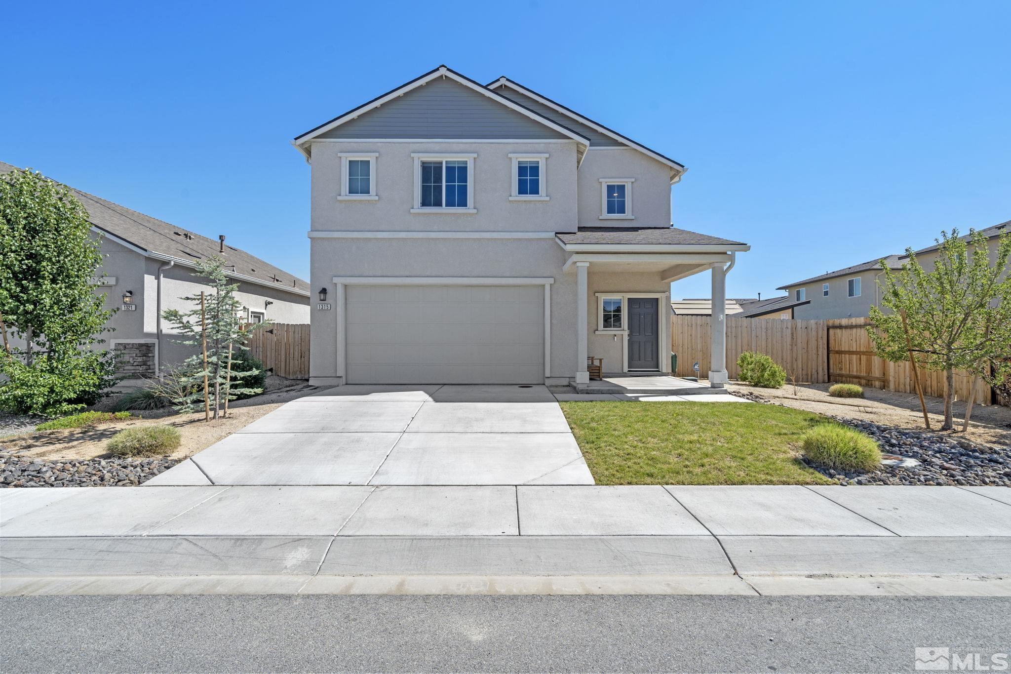 a front view of a house with a yard and a garage