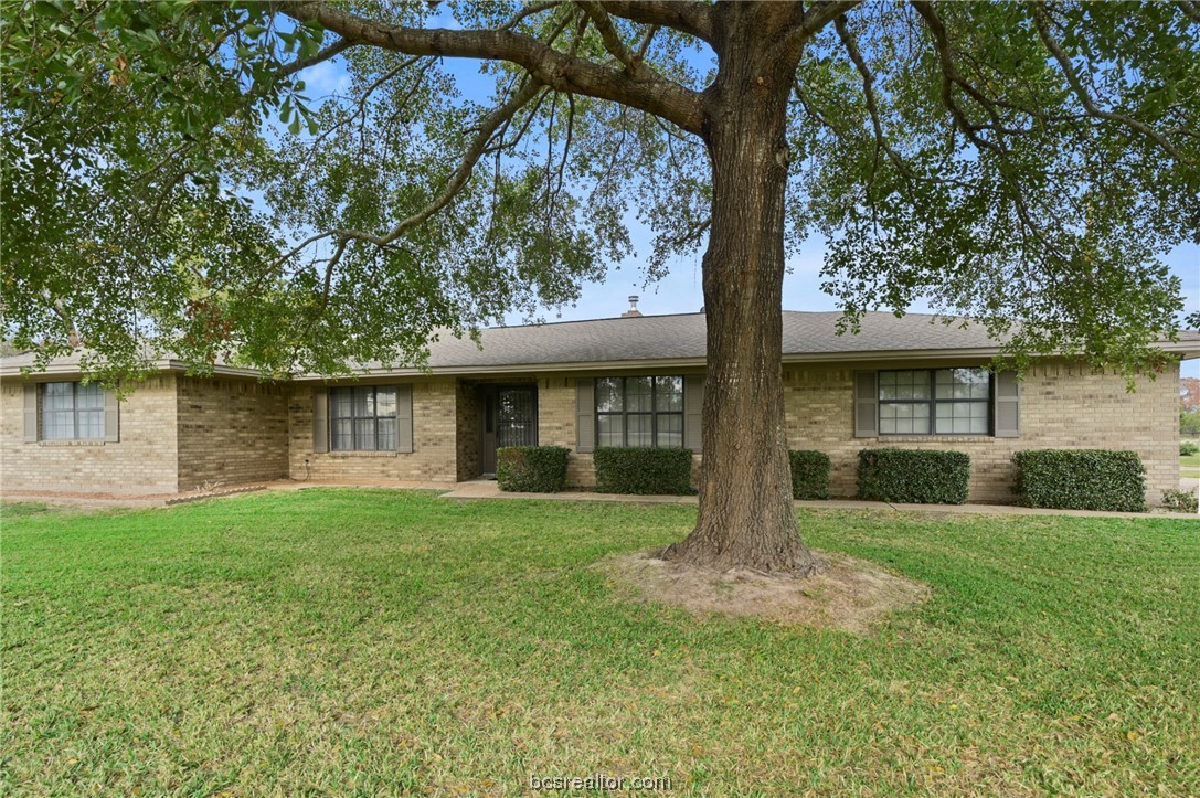 a front view of a house with a garden and yard