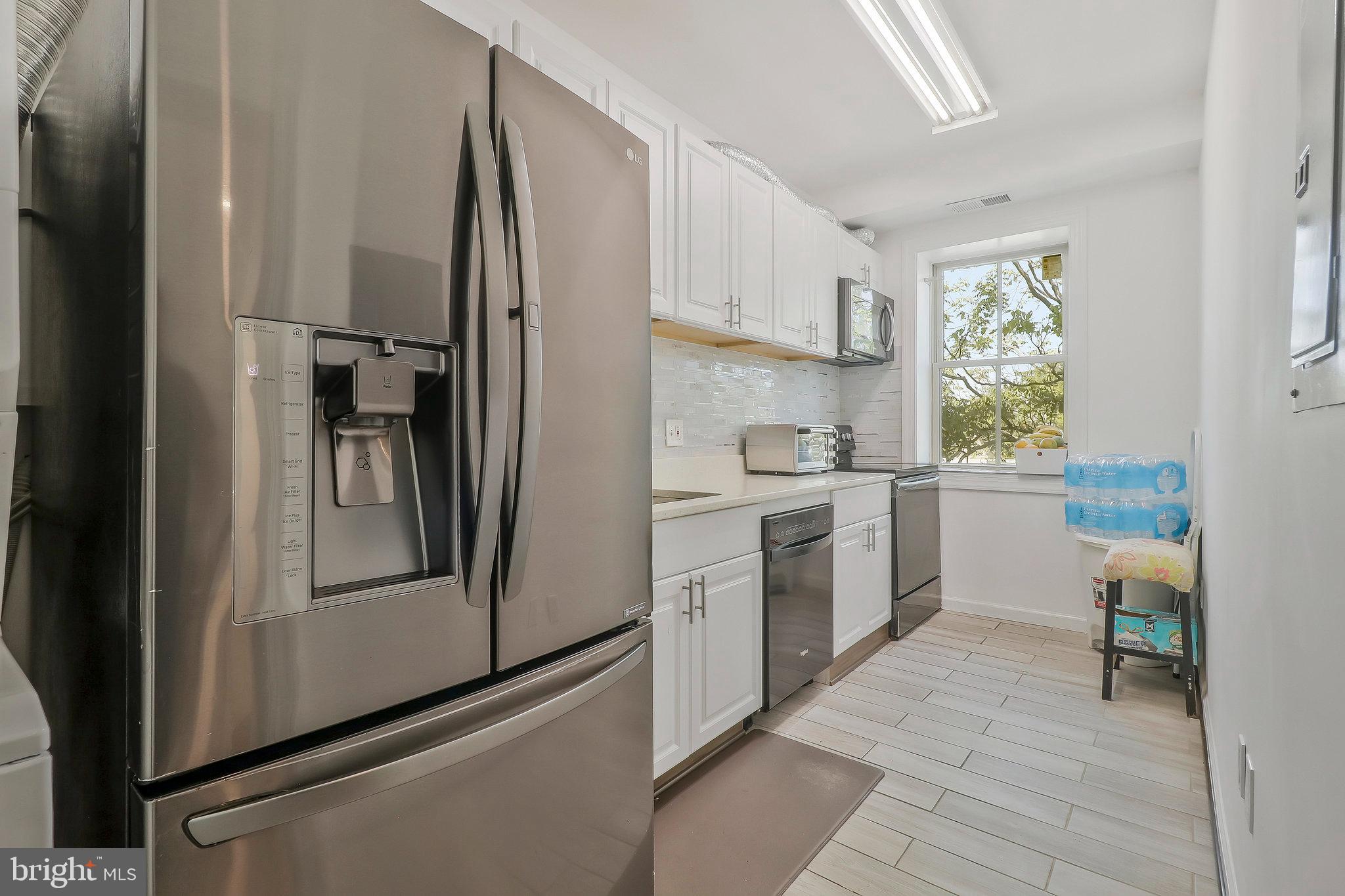 a kitchen with a refrigerator sink and cabinets