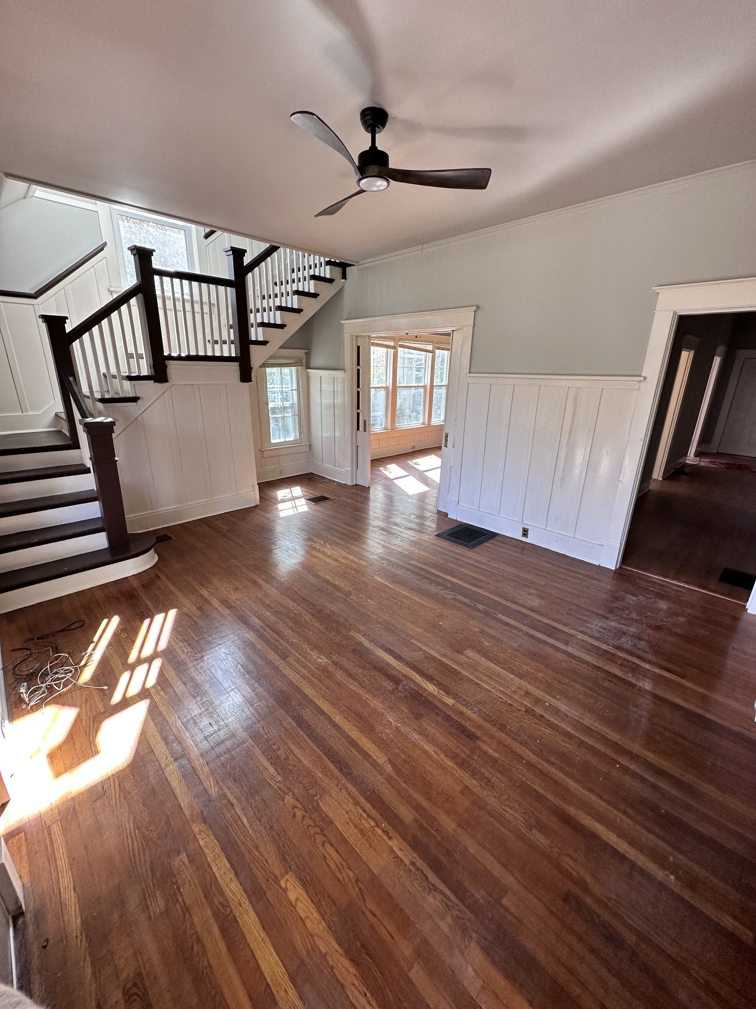 a view of an empty room with wooden floor and a window