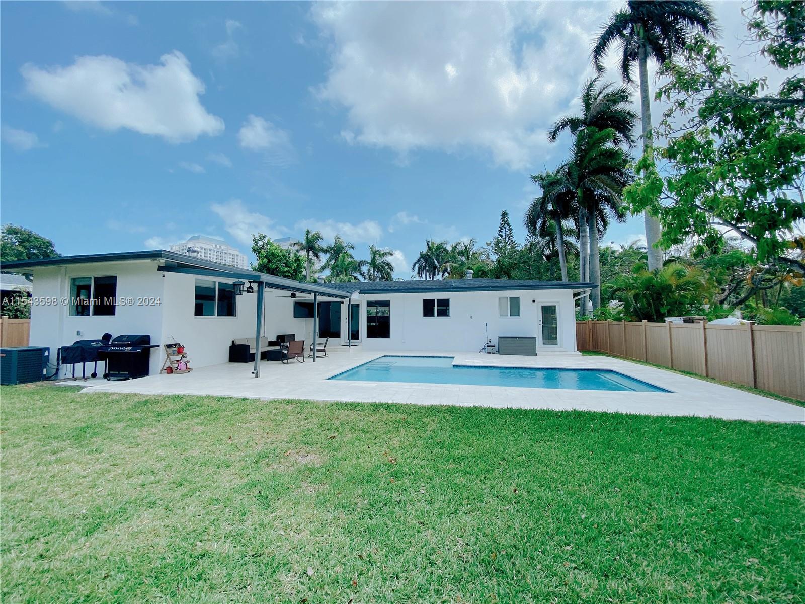 a view of a house with swimming pool and sitting area