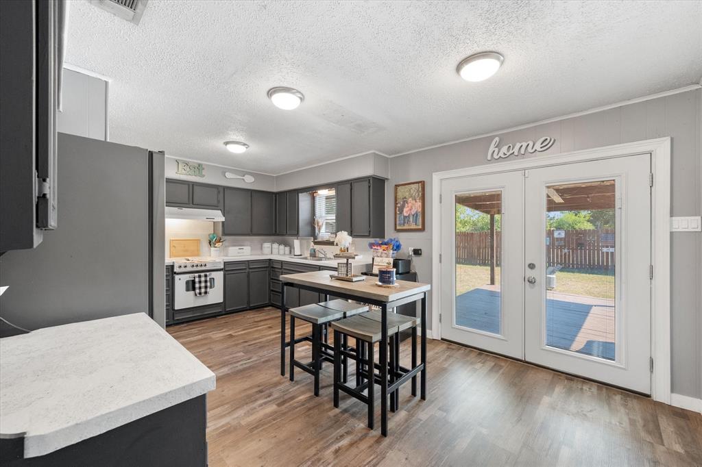 a kitchen with stainless steel appliances wooden floor and dining table