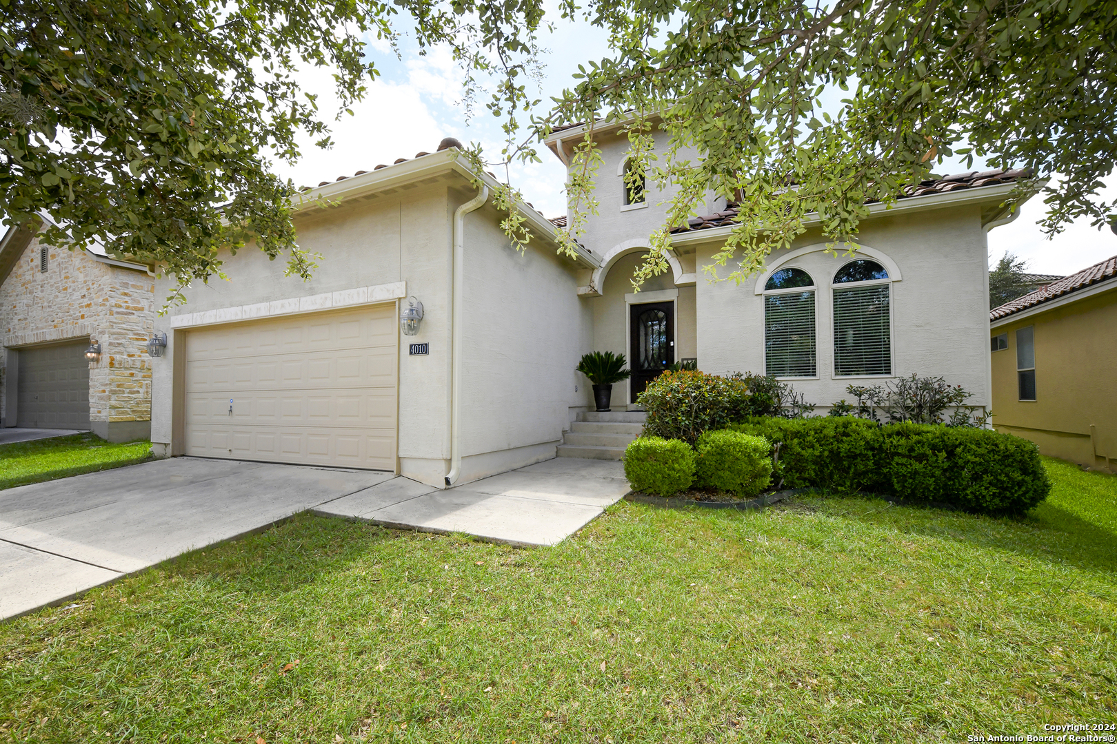 a front view of a house with a garden and yard