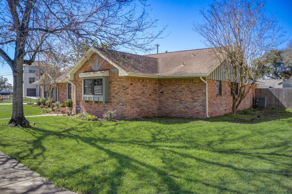 Charming single-story brick home featuring a well-maintained lawn, mature trees, and a cozy design with a welcoming feel in a sunny neighborhood.