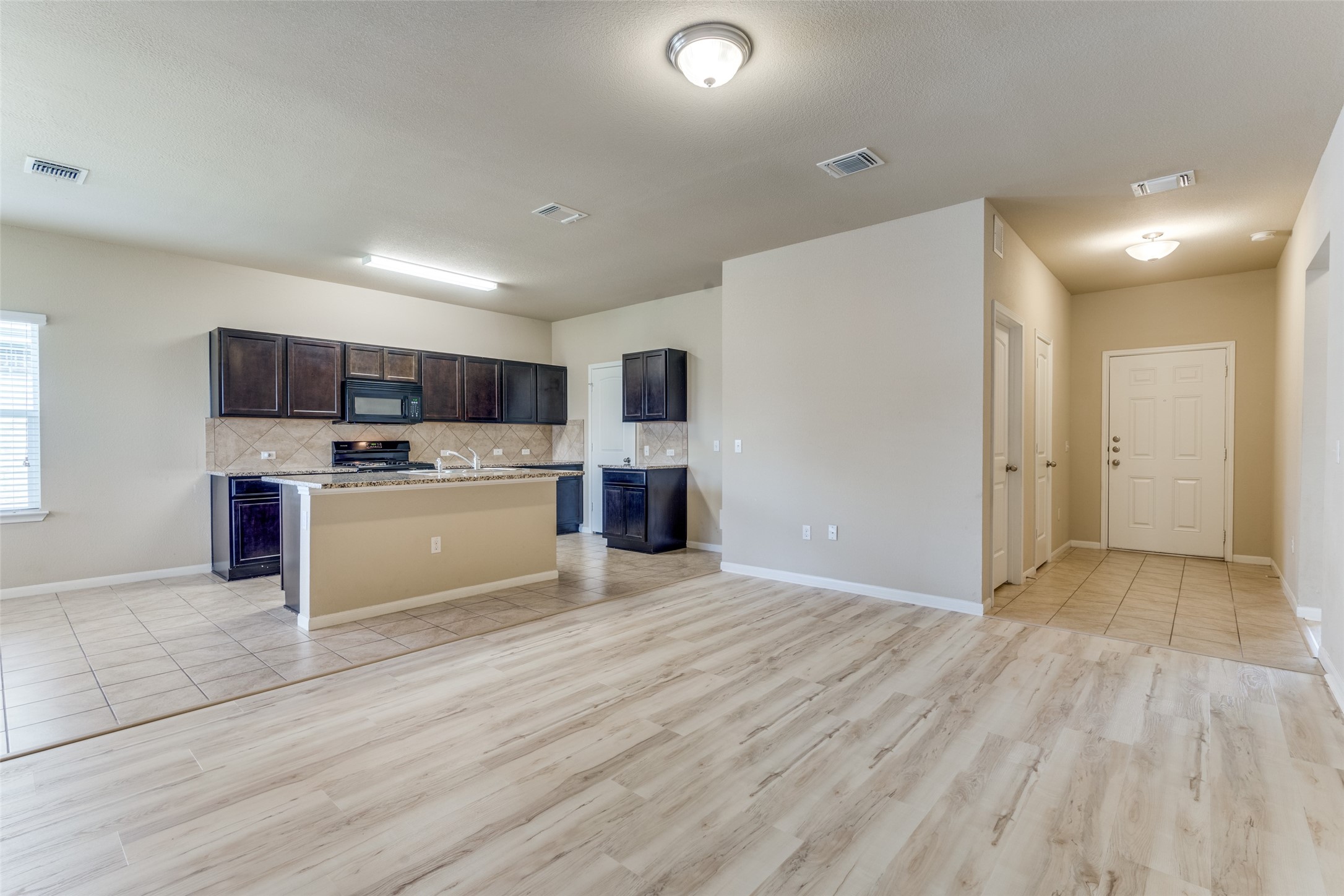 a view of kitchen with microwave oven a sink and cabinets