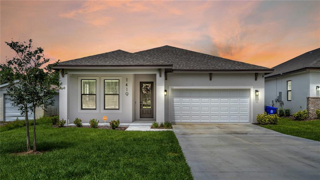 a front view of a house with a yard and garage