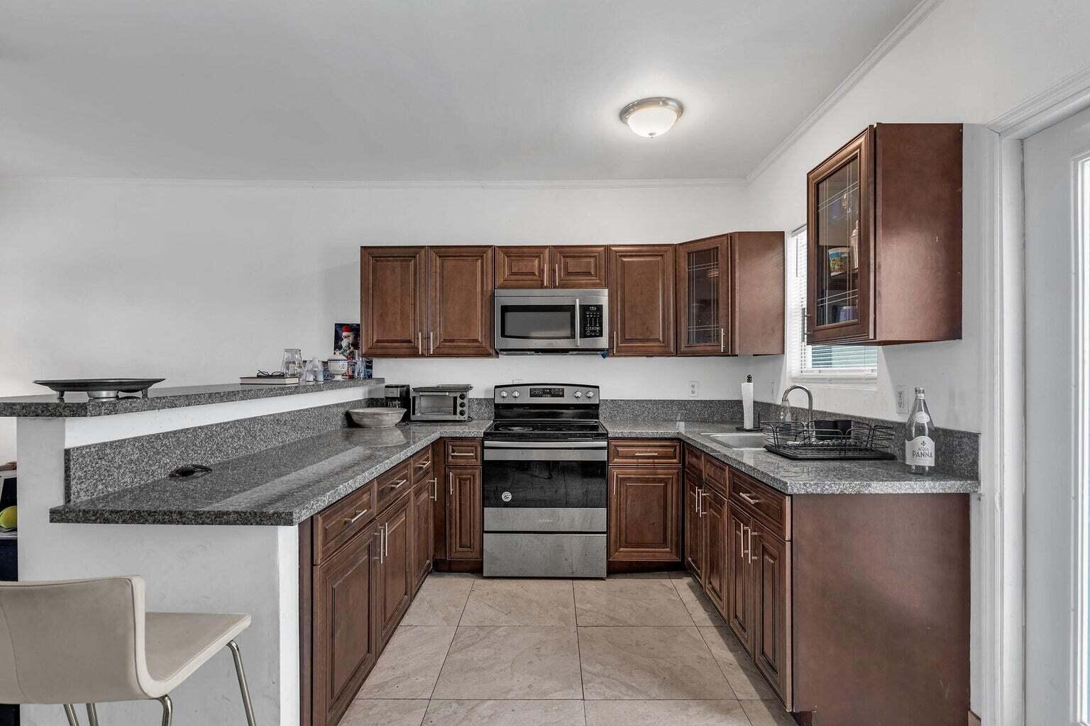 a kitchen with stainless steel appliances granite countertop a stove microwave and sink