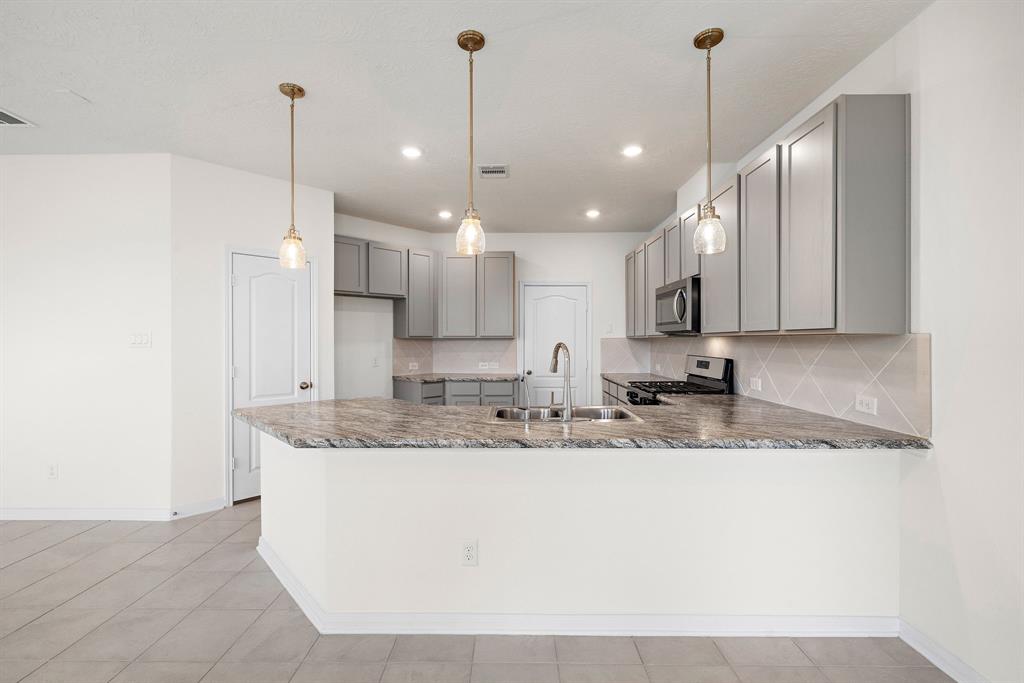 a large kitchen with kitchen island a sink stainless steel appliances and a cabinets