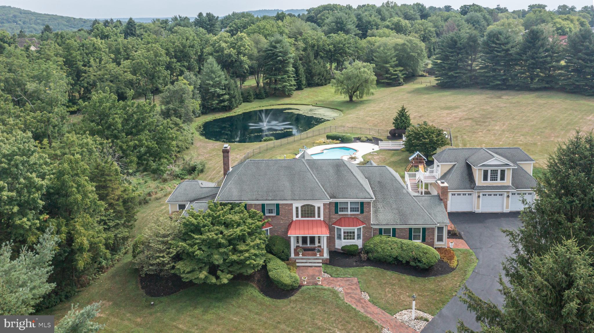 an aerial view of a house with swimming pool and lake view