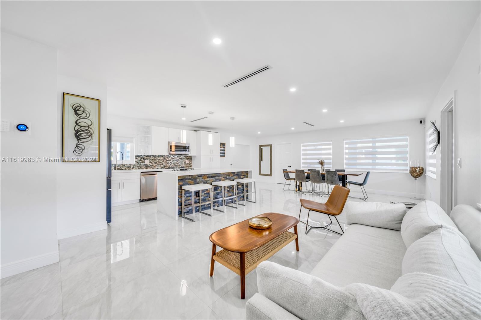 a living room with furniture kitchen view and a table