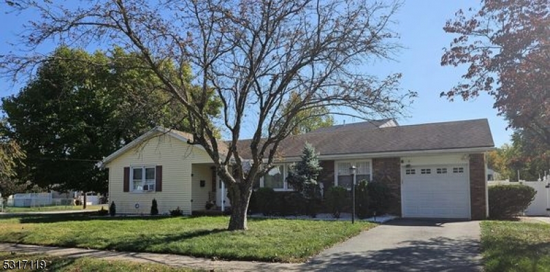 a front view of house with a yard and large trees