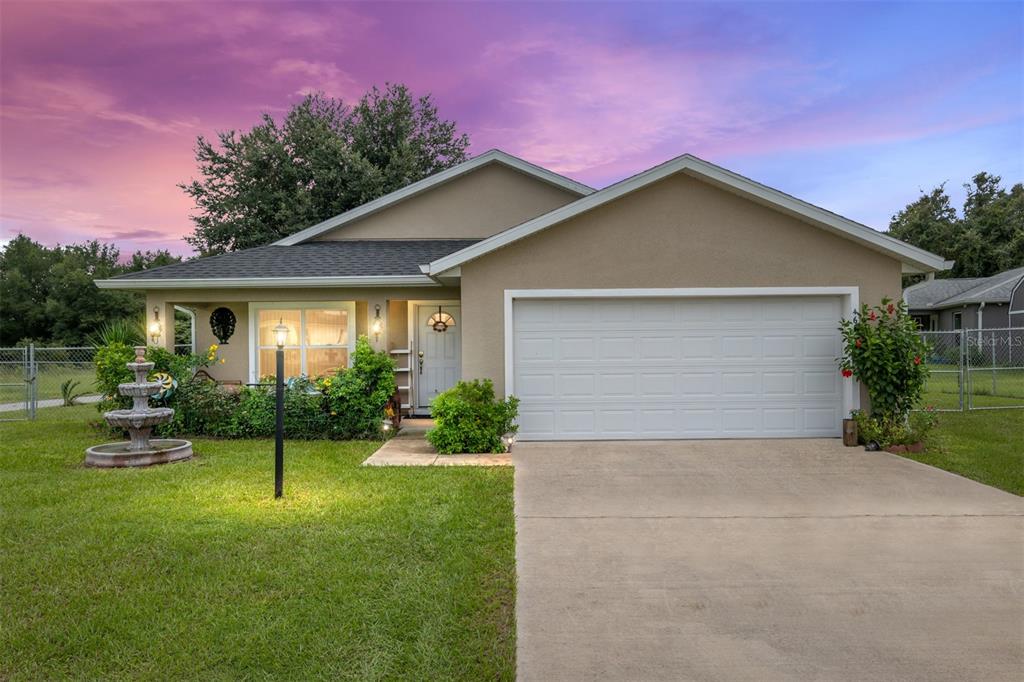 a view of a house with a yard and potted plants