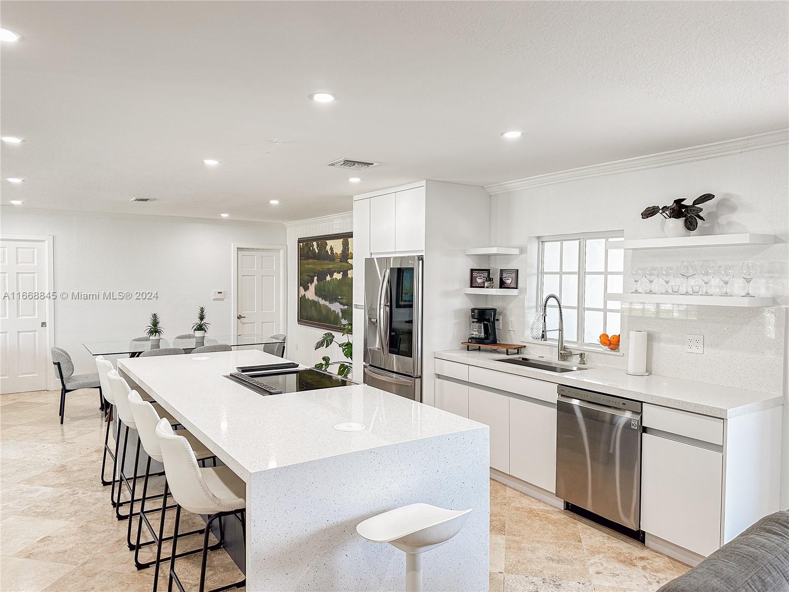 a kitchen with a dining table chairs appliances and cabinets