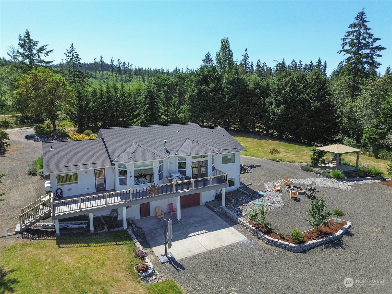 an aerial view of a house with swimming pool and trees in the background