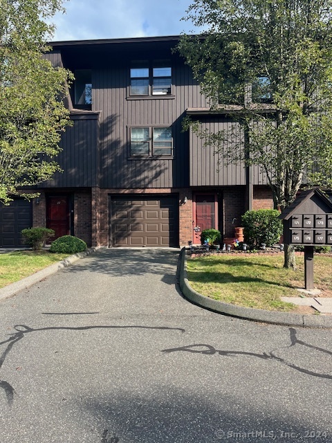 a front view of a house with a garden and trees