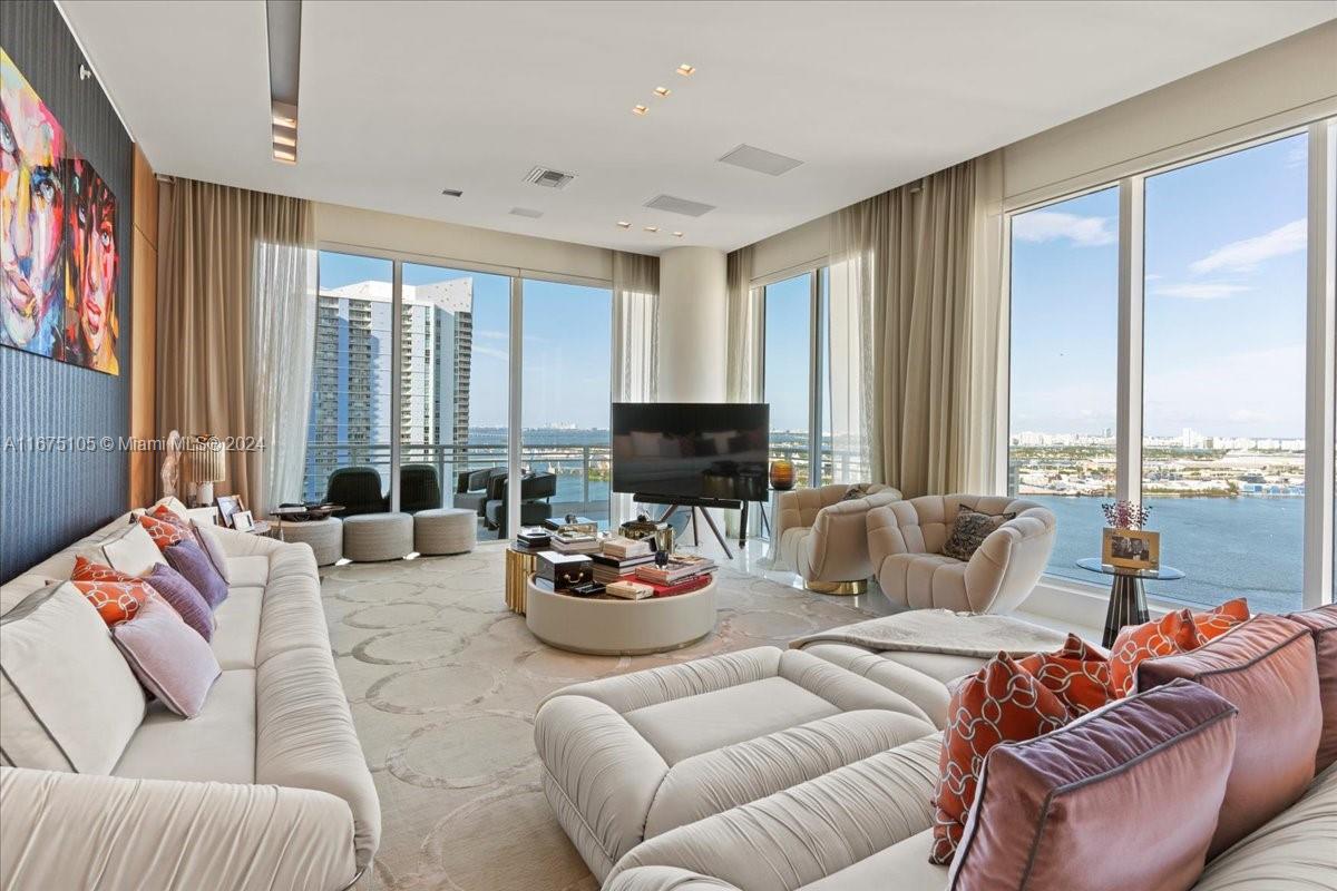 a living room with furniture and large windows