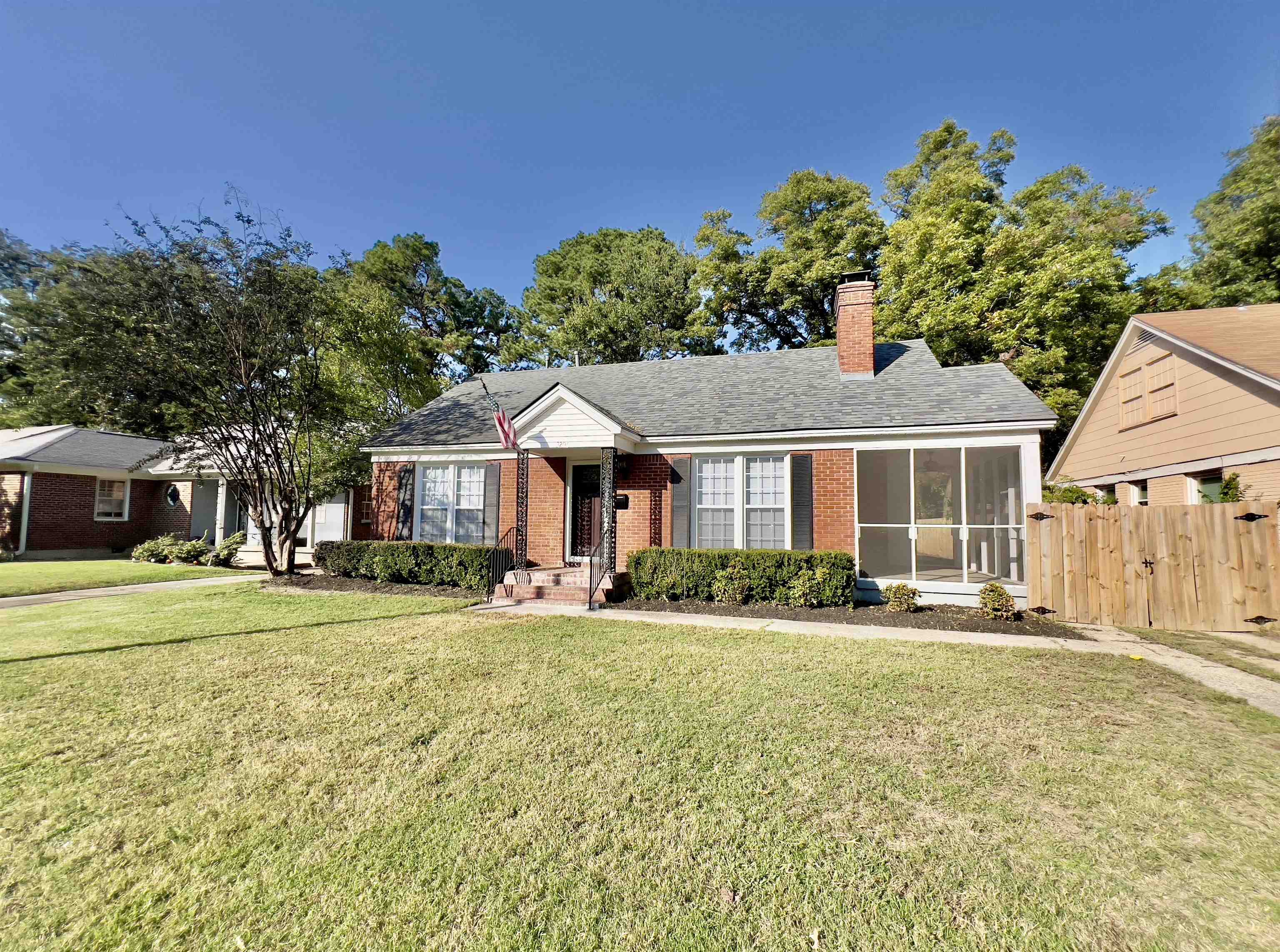 View of front facade with a front yard and a sunroom