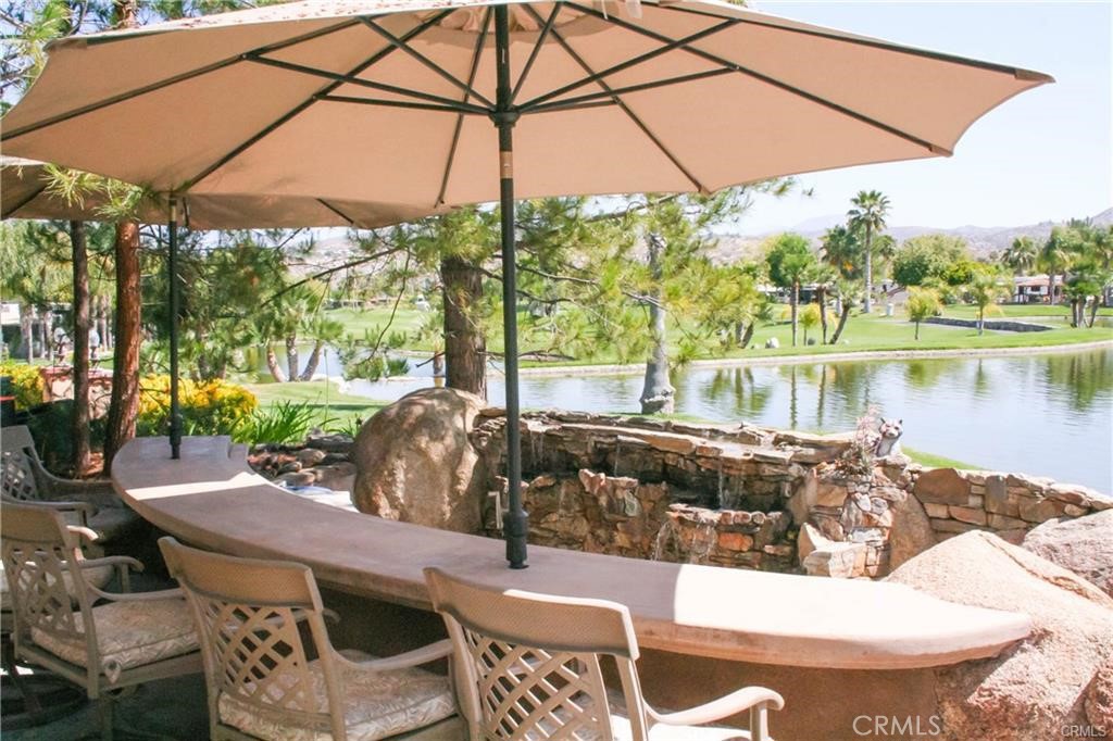 a view of a patio with table and chairs under an umbrella