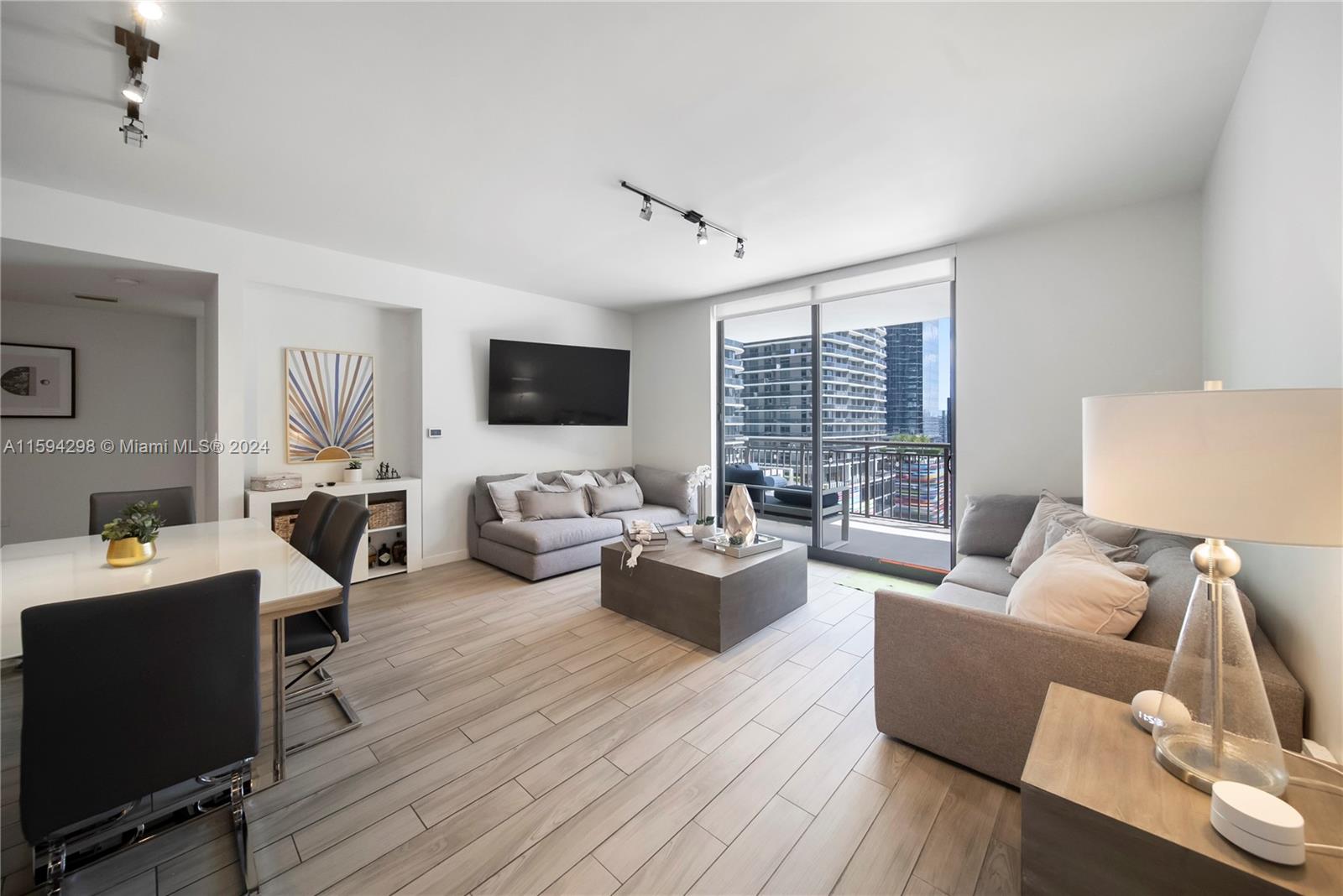 a living room with furniture a flat screen tv and wooden floor