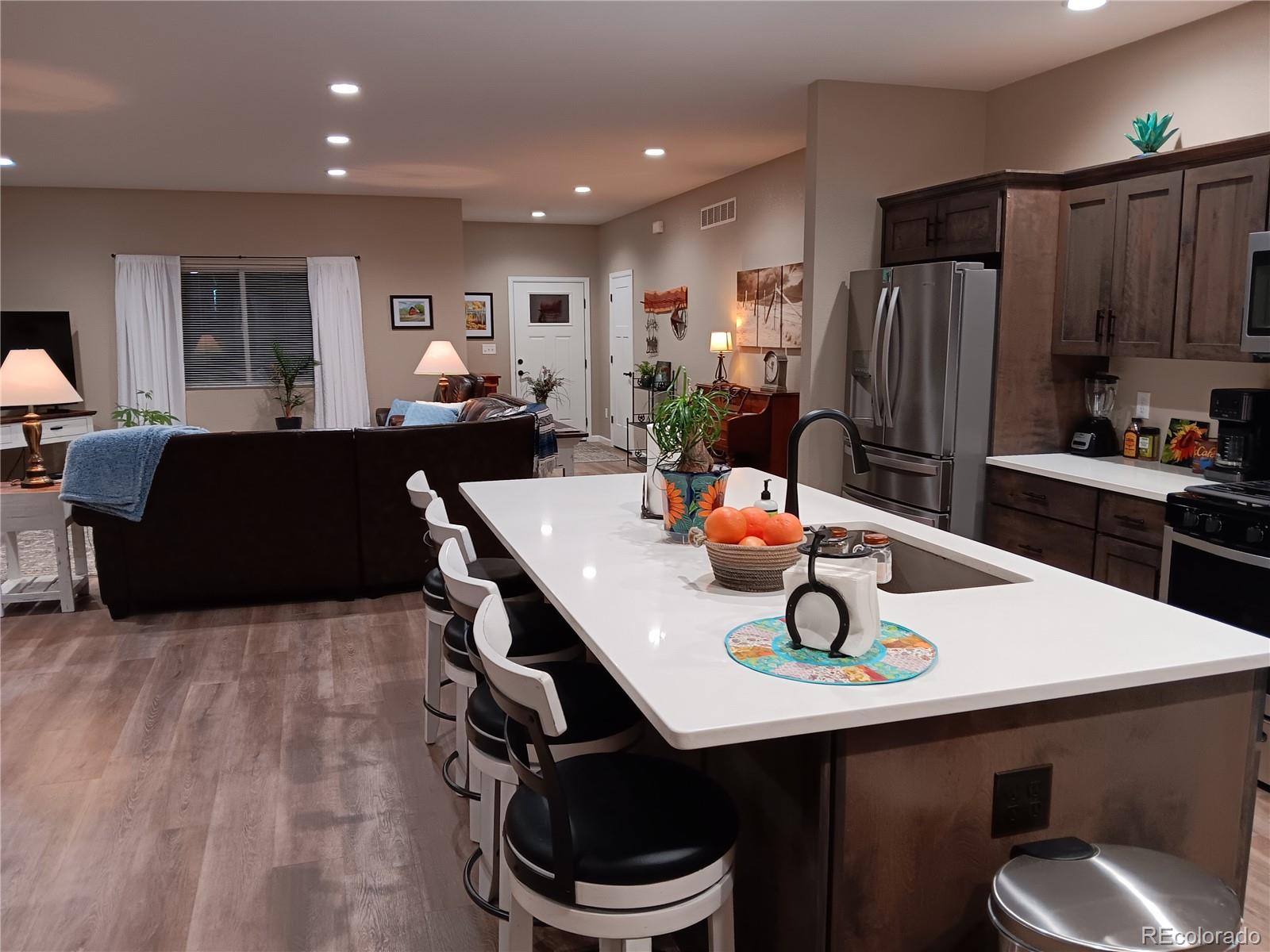 a kitchen with stainless steel appliances a sink a table and chairs