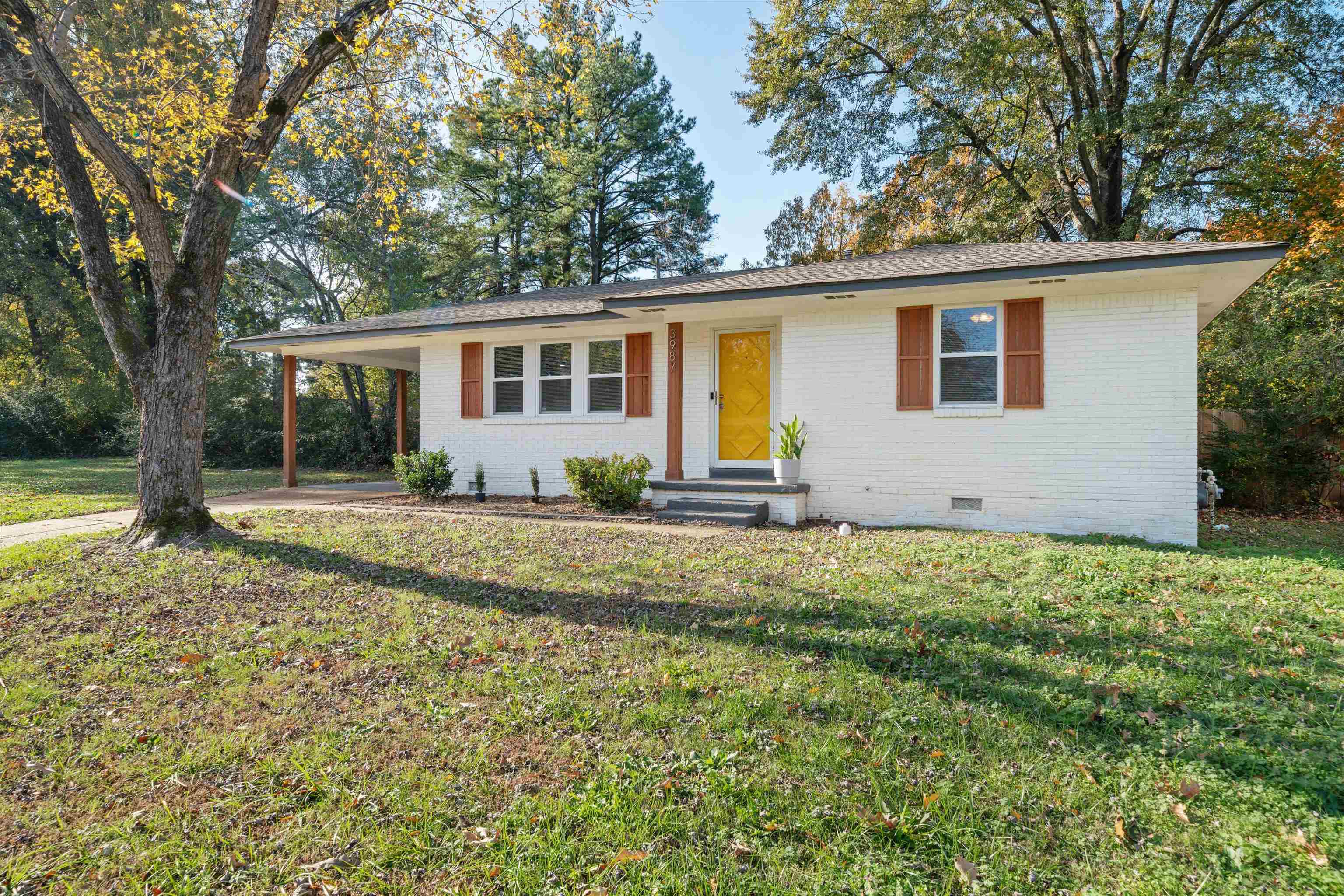 a front view of house with yard and trees around