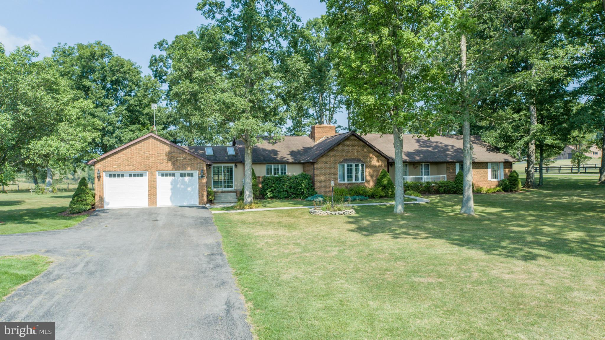 a front view of a house with yard and green space