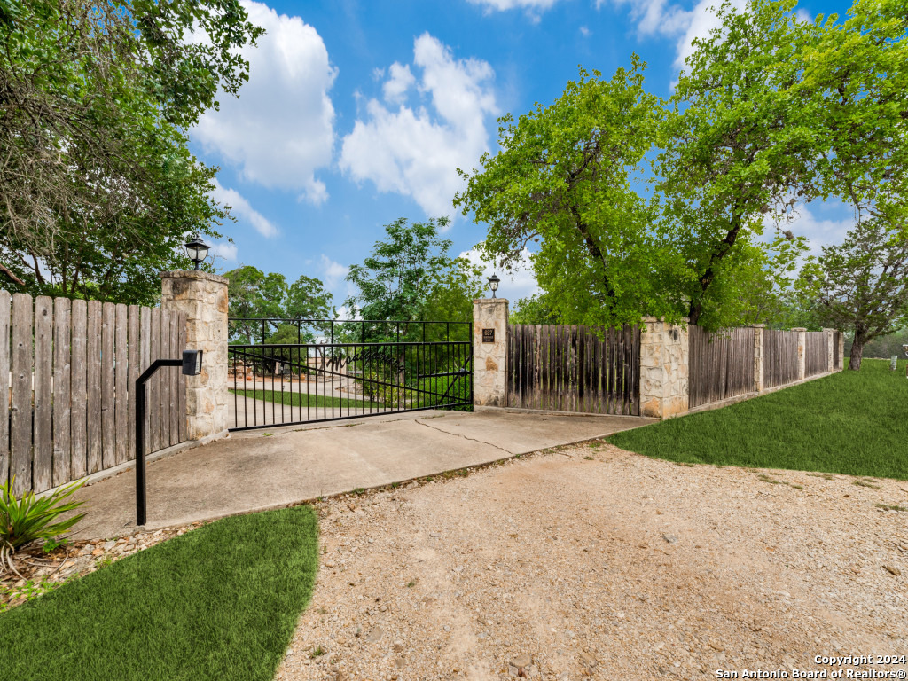 a view of a backyard with wooden fence and a bench