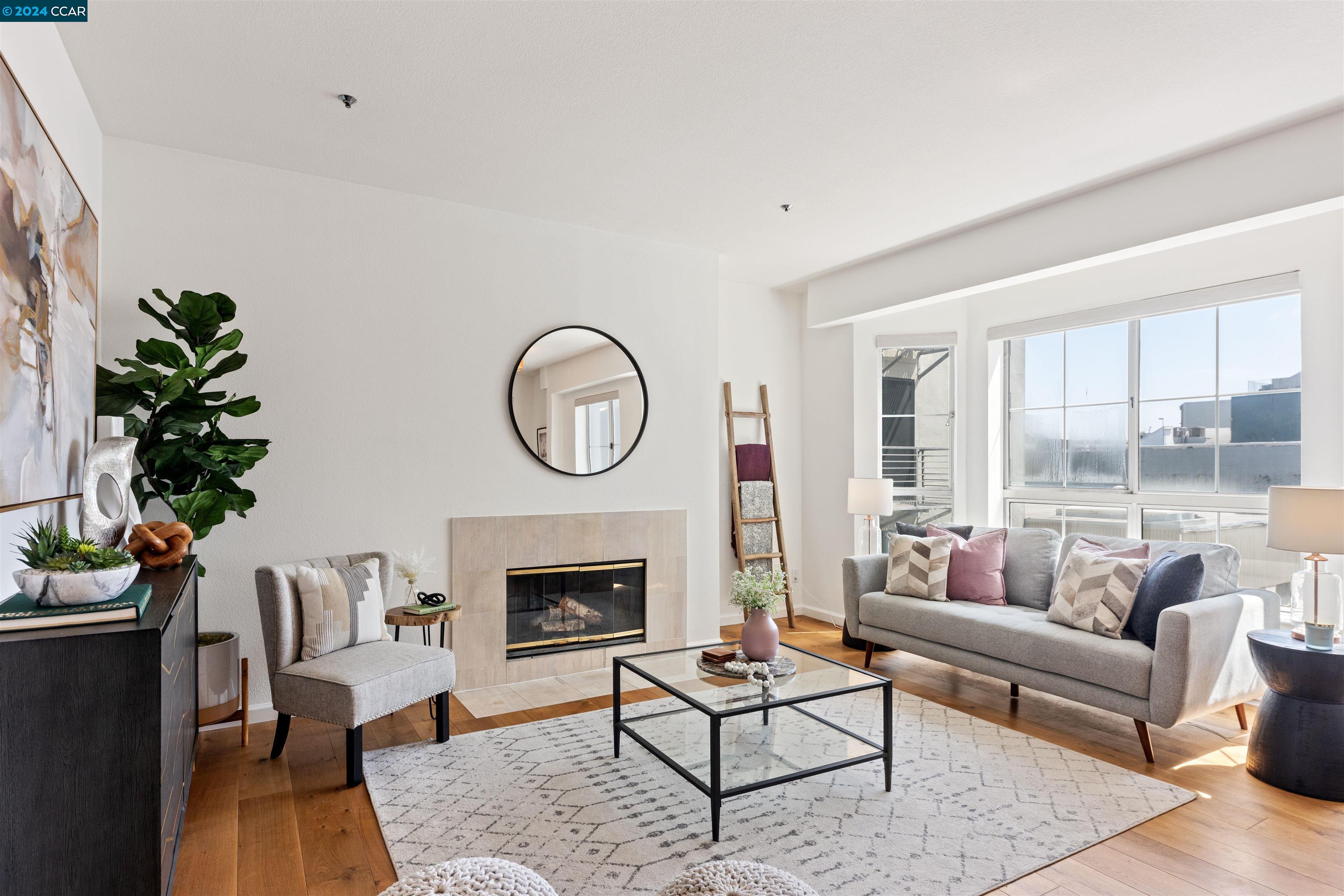 a living room with furniture a rug a fireplace and a potted plant