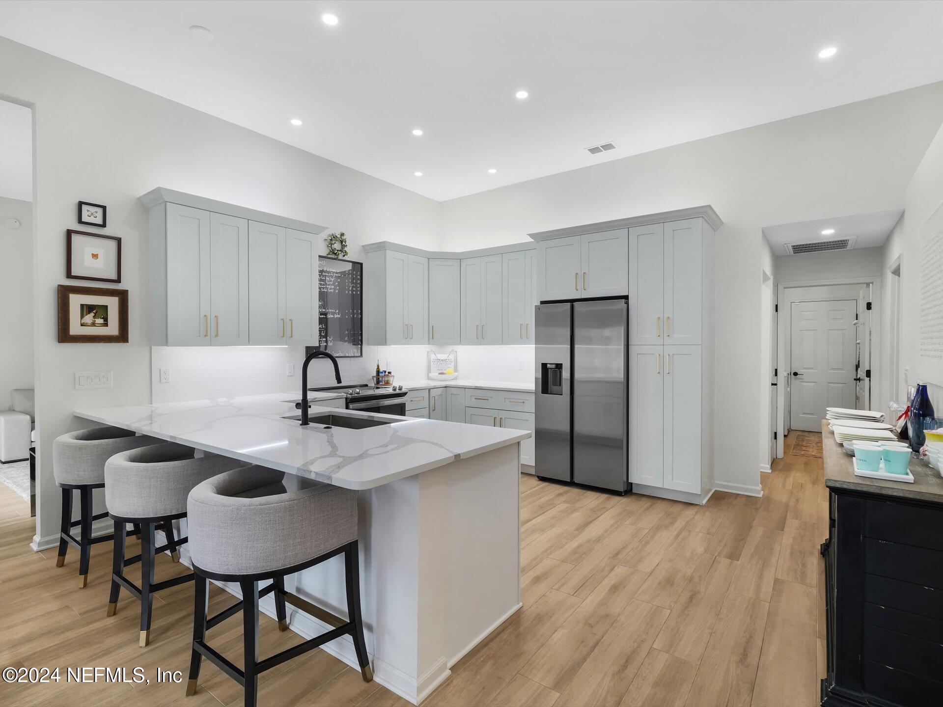 a kitchen with kitchen island a counter top space a sink stainless steel appliances and cabinets