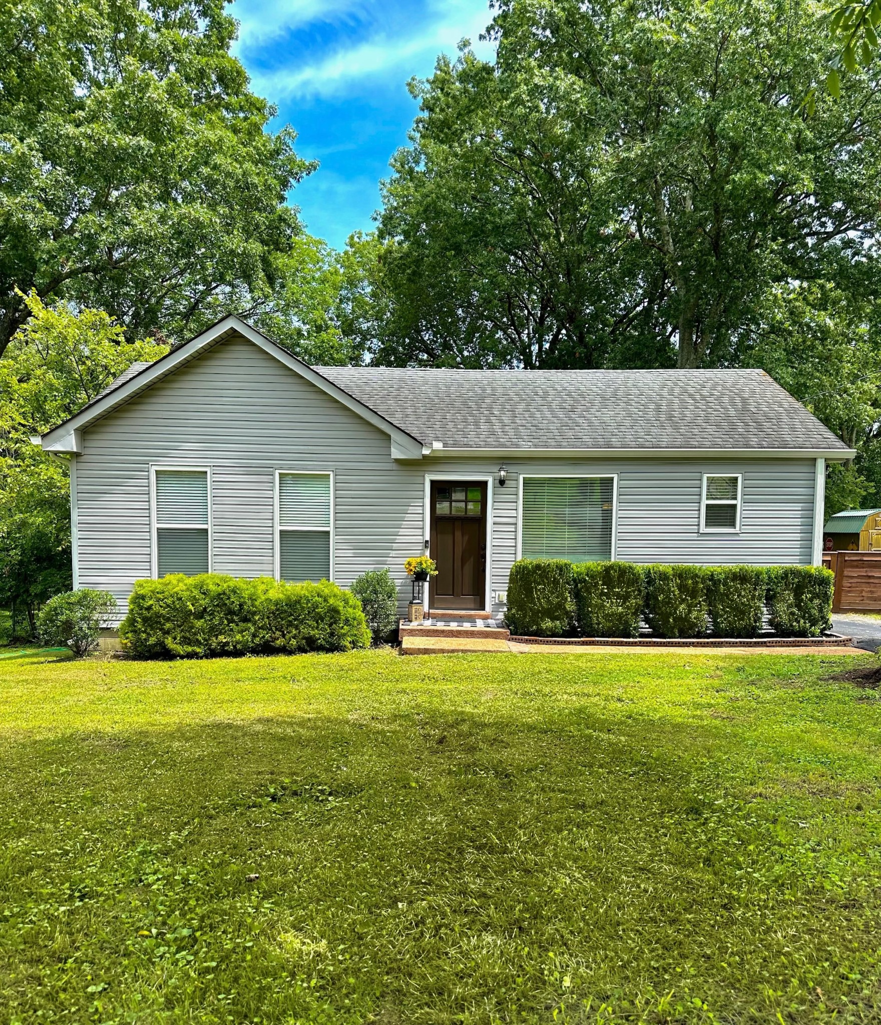 a view of a house with a yard and potted plants