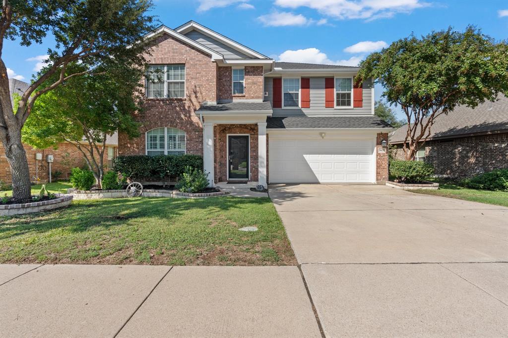 View of front of house with a front yard and a garage