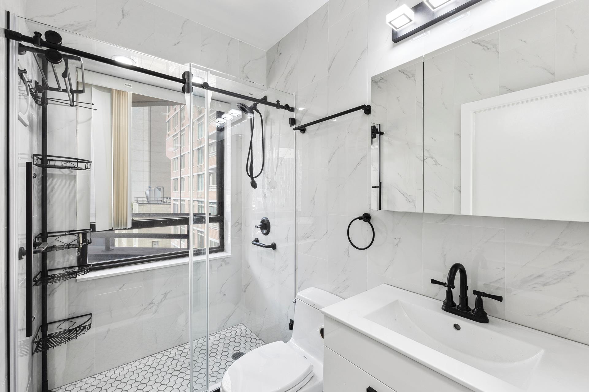 a bathroom with a sink toilet and shower