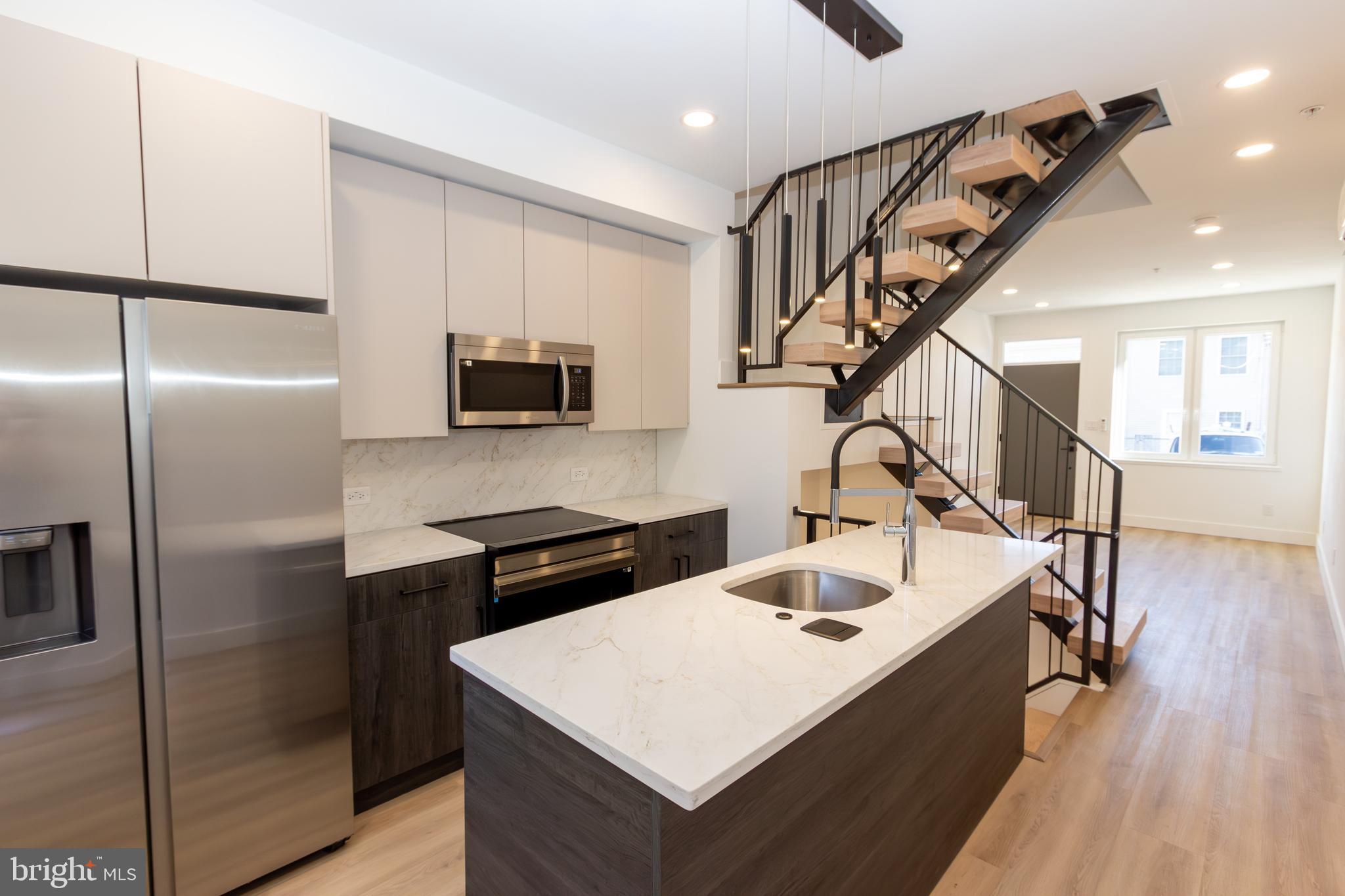 a kitchen with kitchen island a sink appliances and cabinets