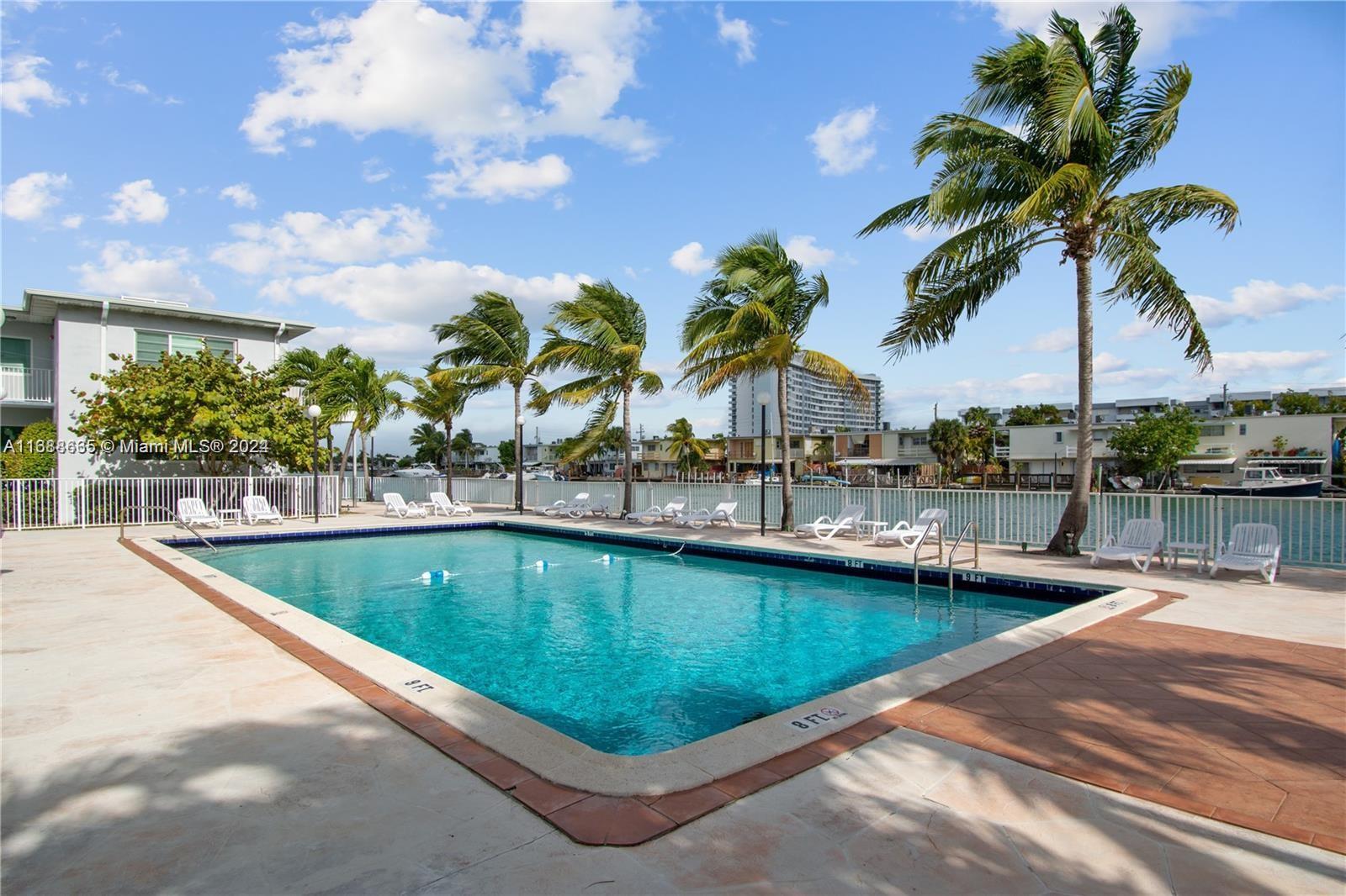 a view of swimming pool with outdoor seating and plants