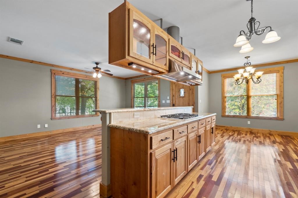 a kitchen with stainless steel appliances granite countertop a stove a sink and a wooden floors