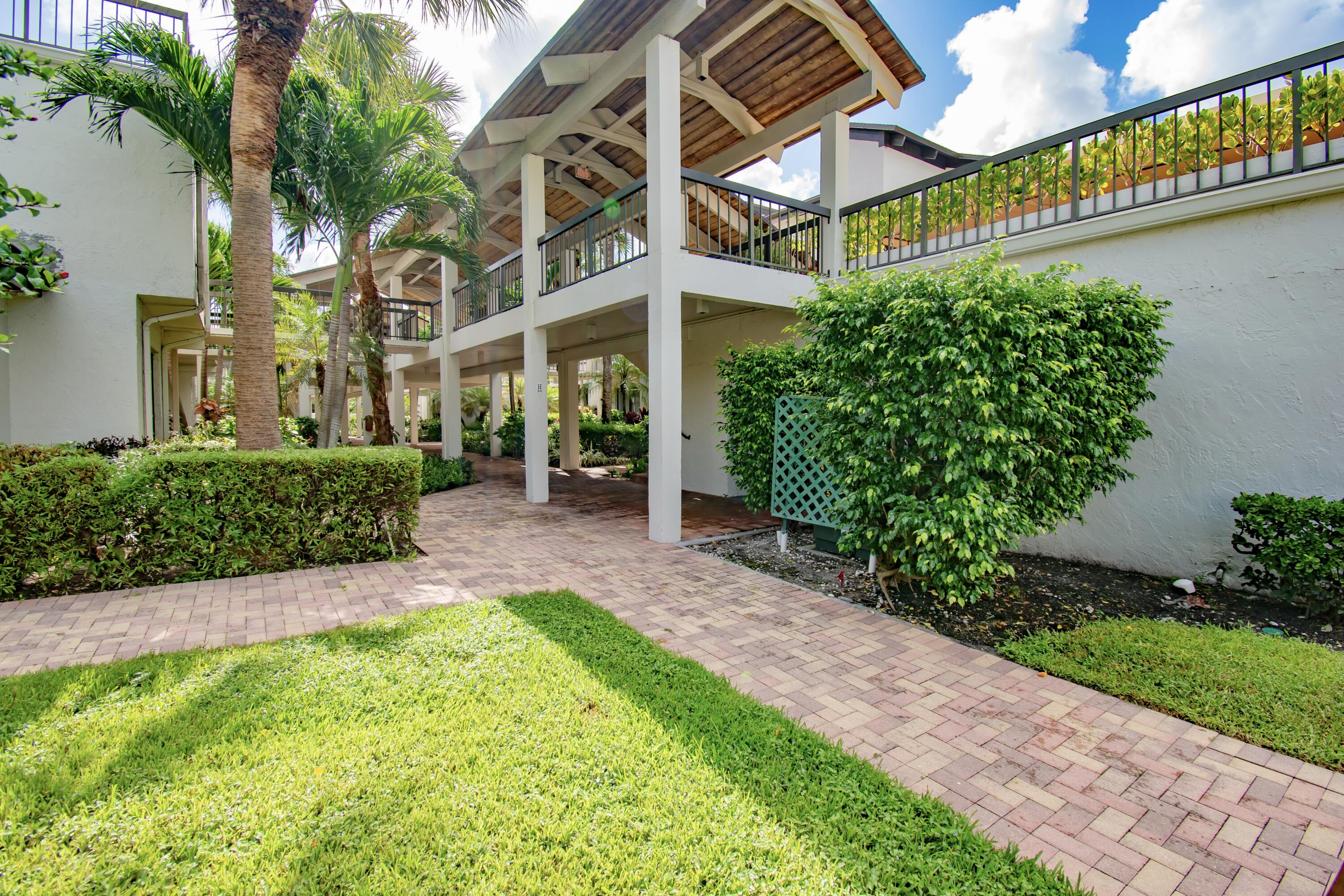 a view of a building with a yard and plants