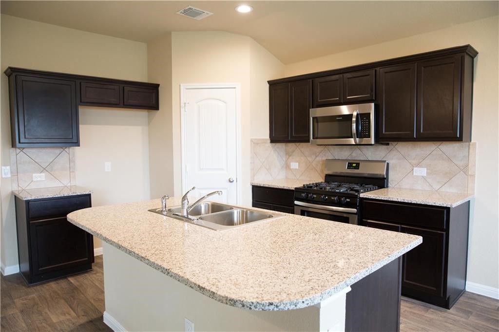 a kitchen with granite countertop a stove and a sink