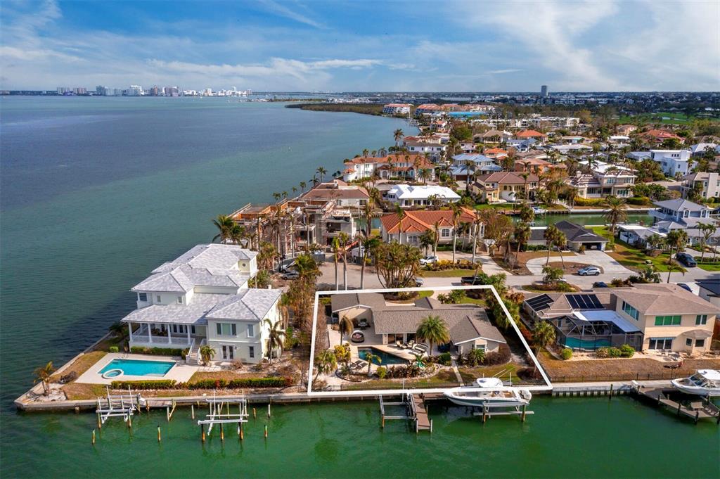 an aerial view of residential houses with outdoor space and ocean view