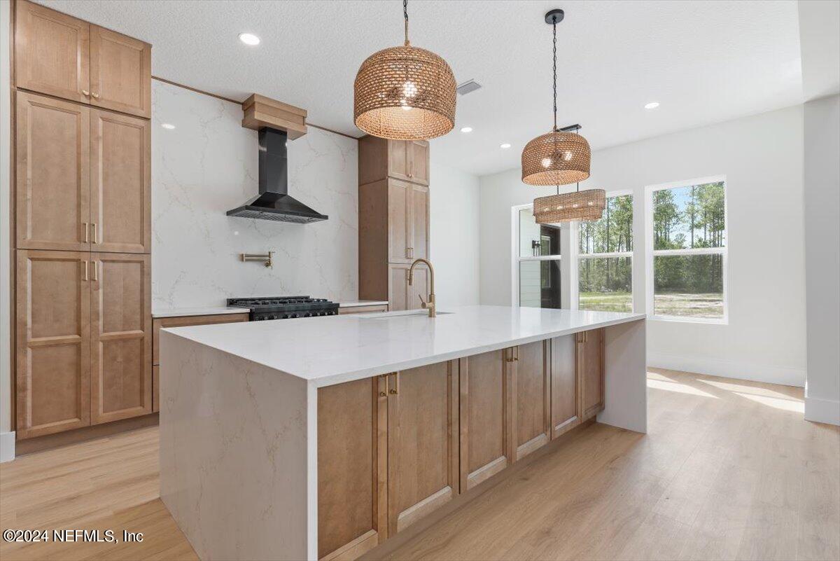 a kitchen with stainless steel appliances granite countertop a sink a refrigerator and a wooden floor